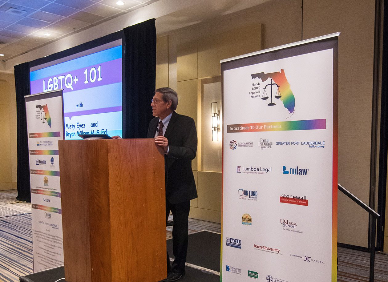 Tony Karrat at a podium opening the LGBTQ Summit.