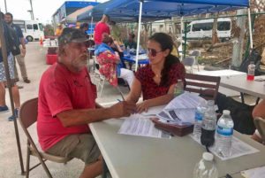 client and attorney talking under tent at outdoor hurricane relief clinic