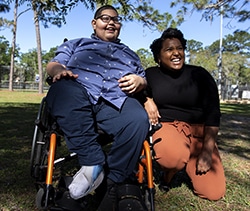 TJ Johnson smiles as he poses for portraits with his lawyer, Abigail Adkins, at a park near his home in Gainesville, Fla. Adkins fought for Alachua County Public Schools to better accommodate TJ in the classroom. (Photo by Chasity Maynard)
