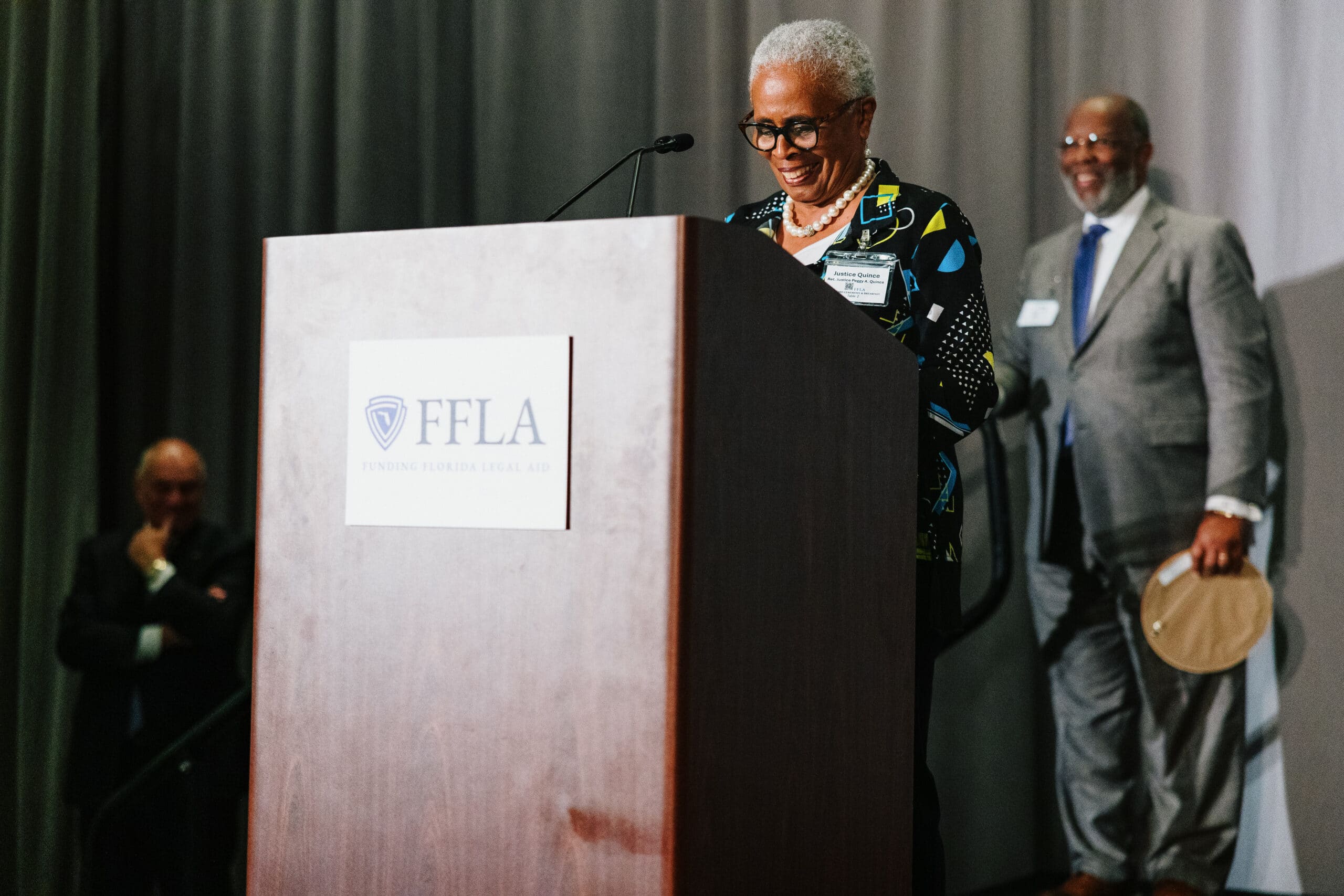 Justice Quince Smiling Podium