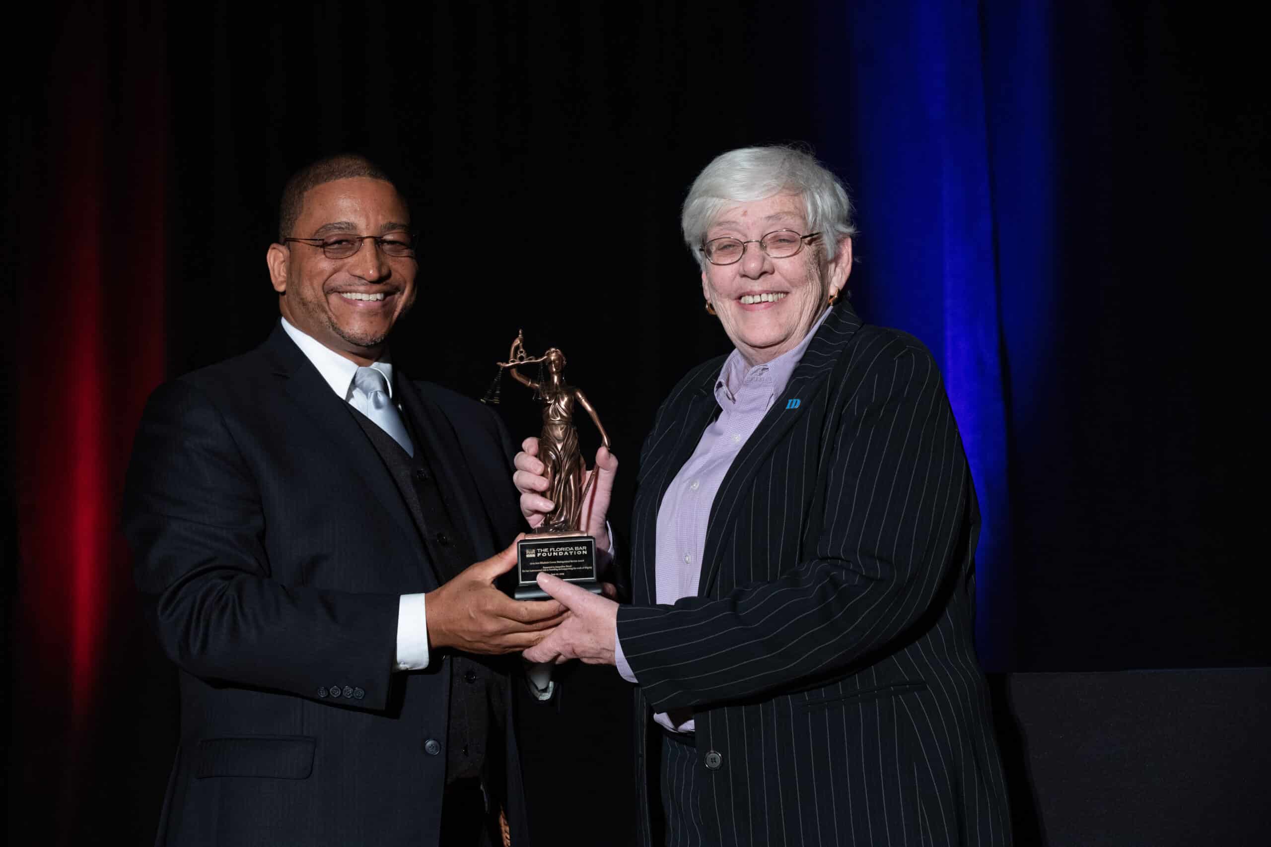 IDignity lawyer Jackie Dowd accepts the 2019 Curran Award from Foundation board member Ray Reid.